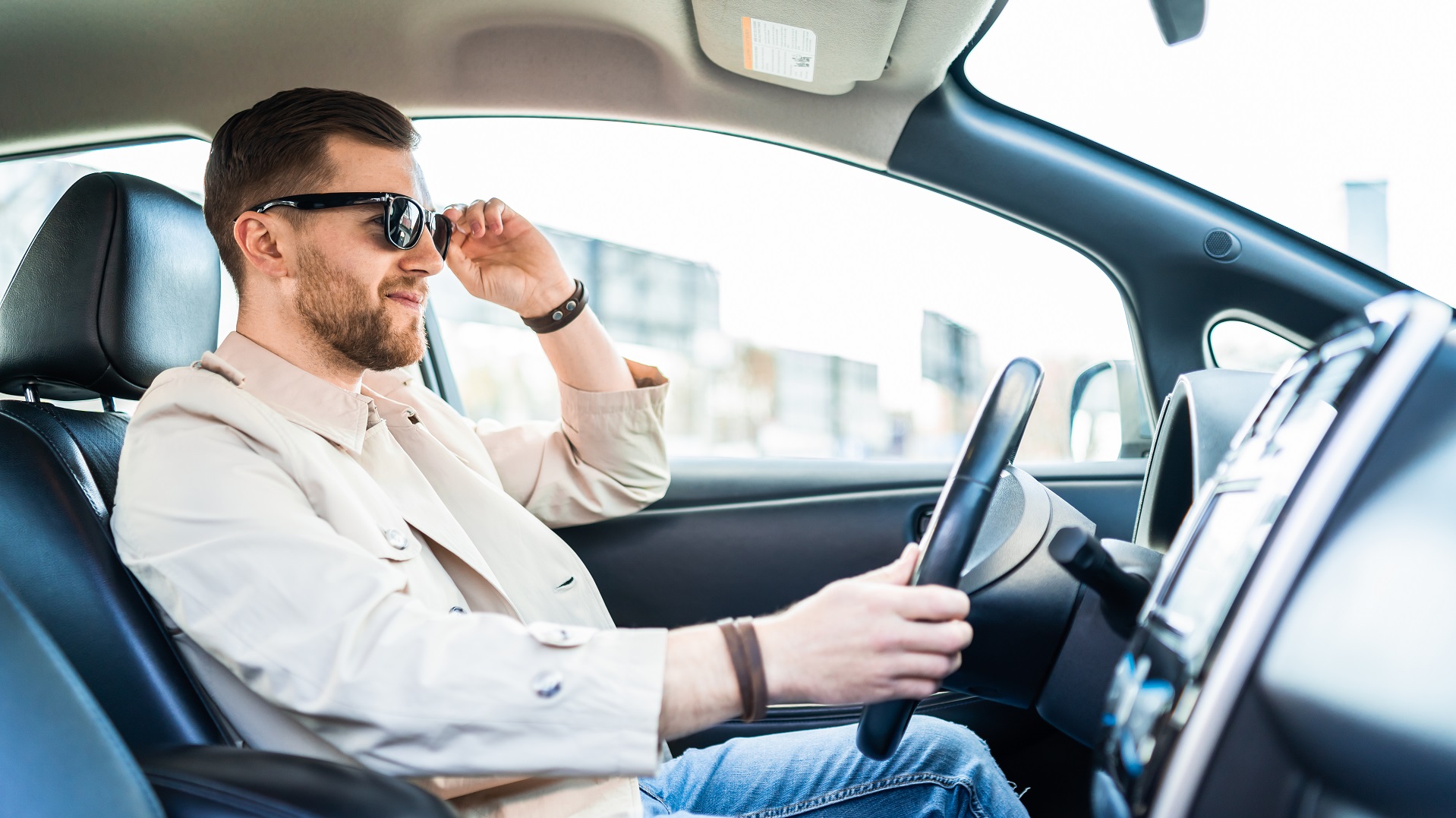 Stylish man in sunglasses driving car